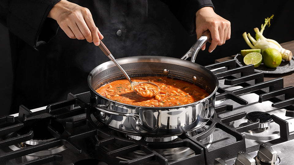 Stainless steel sauté pan with sauce simmering on a gas stove